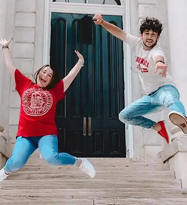 two young adults jumping