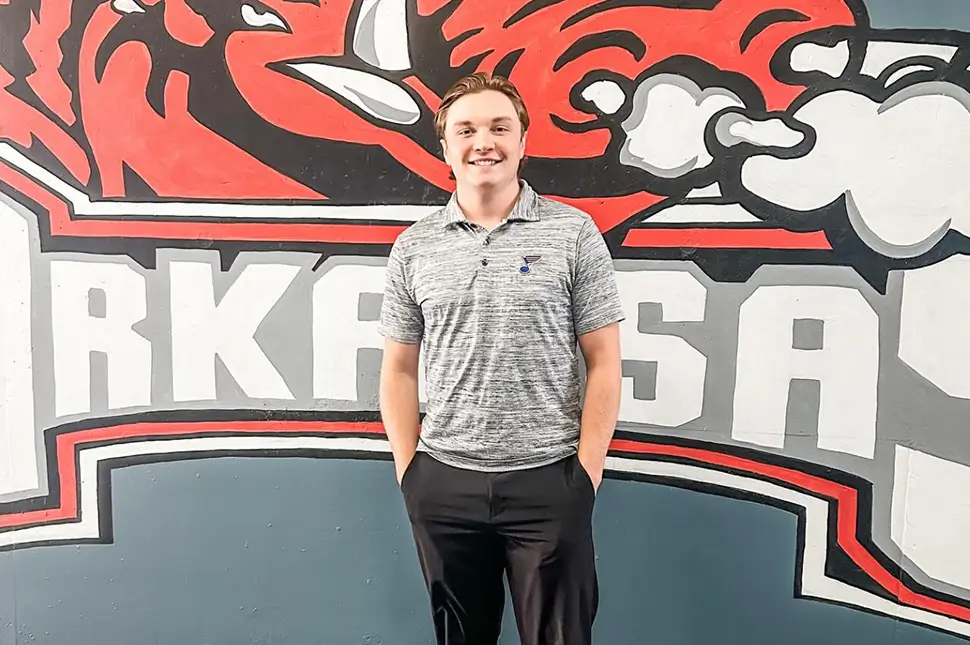 young adult standing in front of a mural